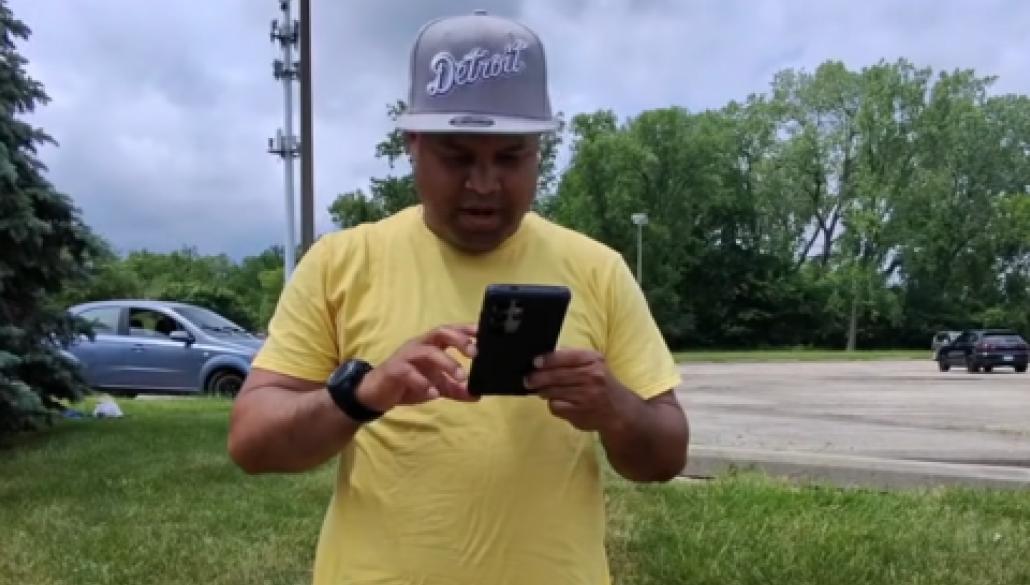 A man looking at a phone in a parking lot