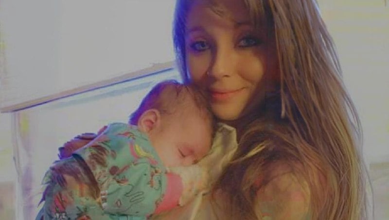 A woman holding a sleeping baby